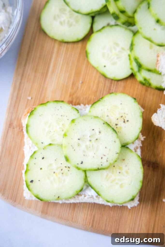 Cucumber Sandwiches 4 Placing thinly sliced cucumbers onto a slice of white bread already spread with herbed cream cheese.