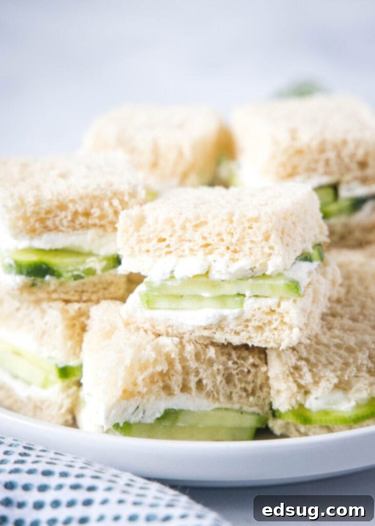 Cucumber Sandwiches 6 Neatly stacked cucumber sandwiches on a pristine white plate, showcasing their delicate layers and perfect slicing.