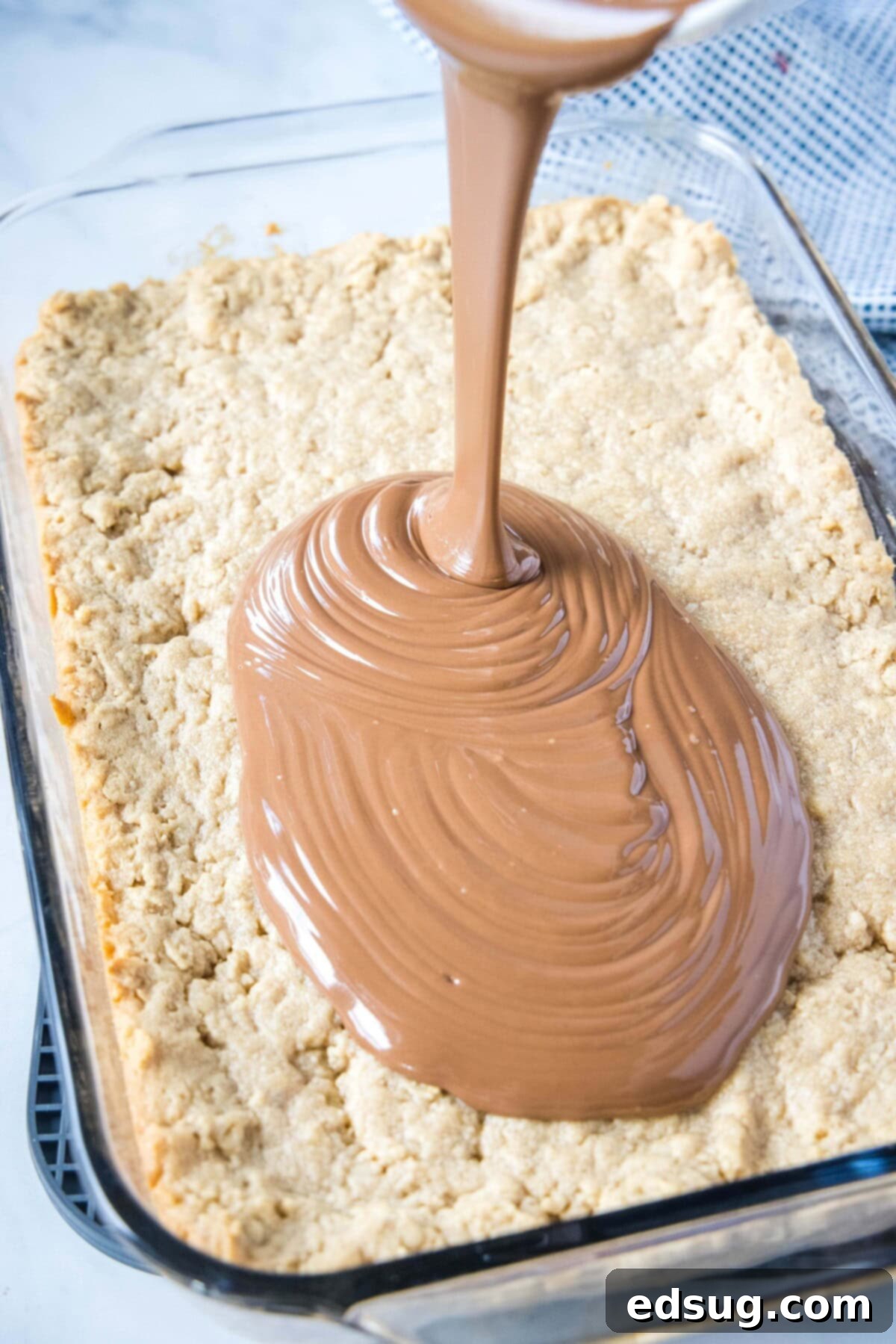Chewy Peanut Butter Oat Treats 5 pouring chocolate over peanut butter bars