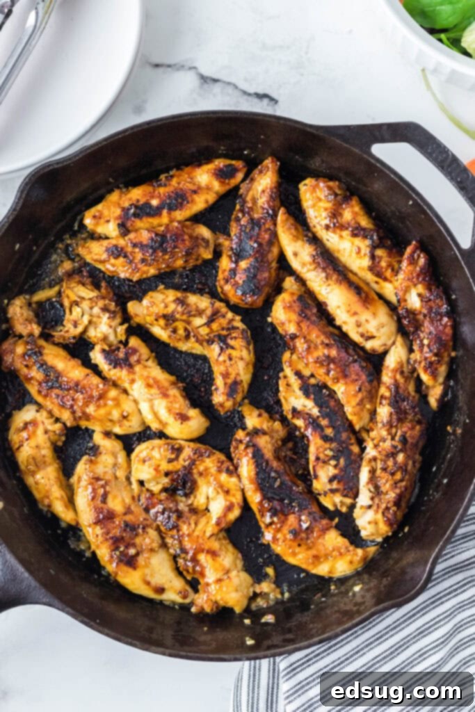 looking down on a cast iron skillet on with chicken tenders