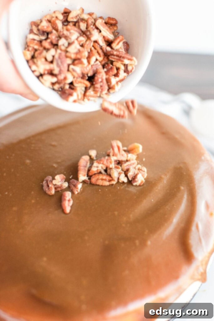 sprinkling pecans over caramel on cheesecake
