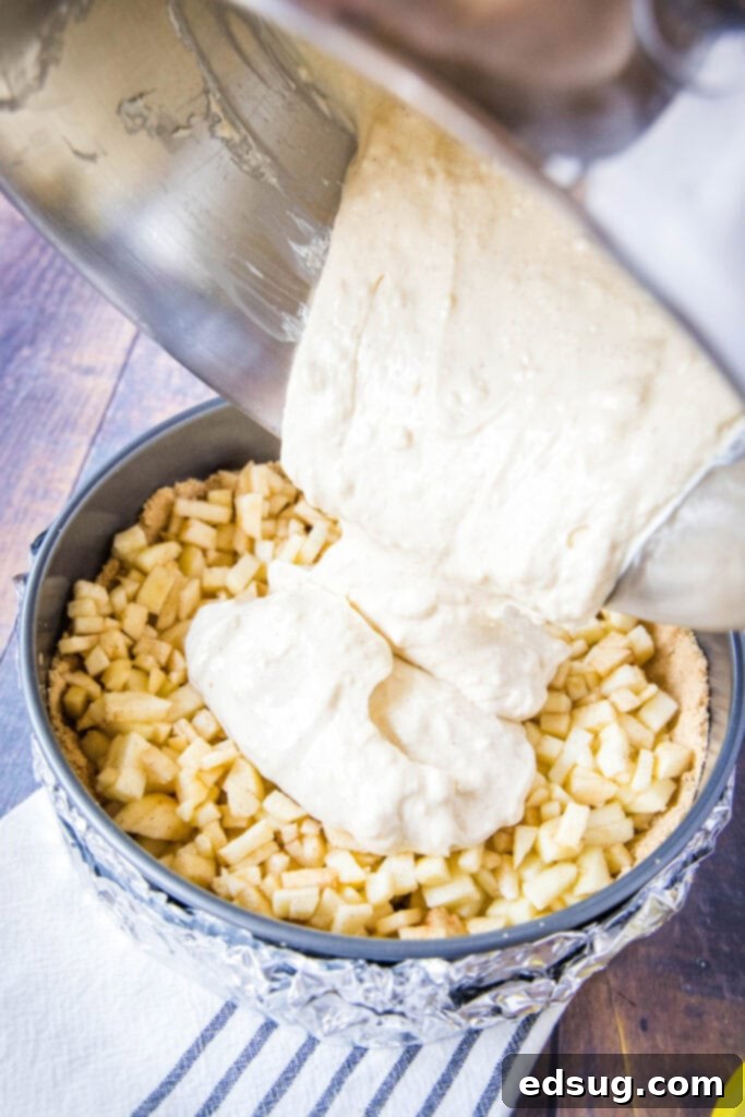 pouring cheesecake over apples in spring form pan