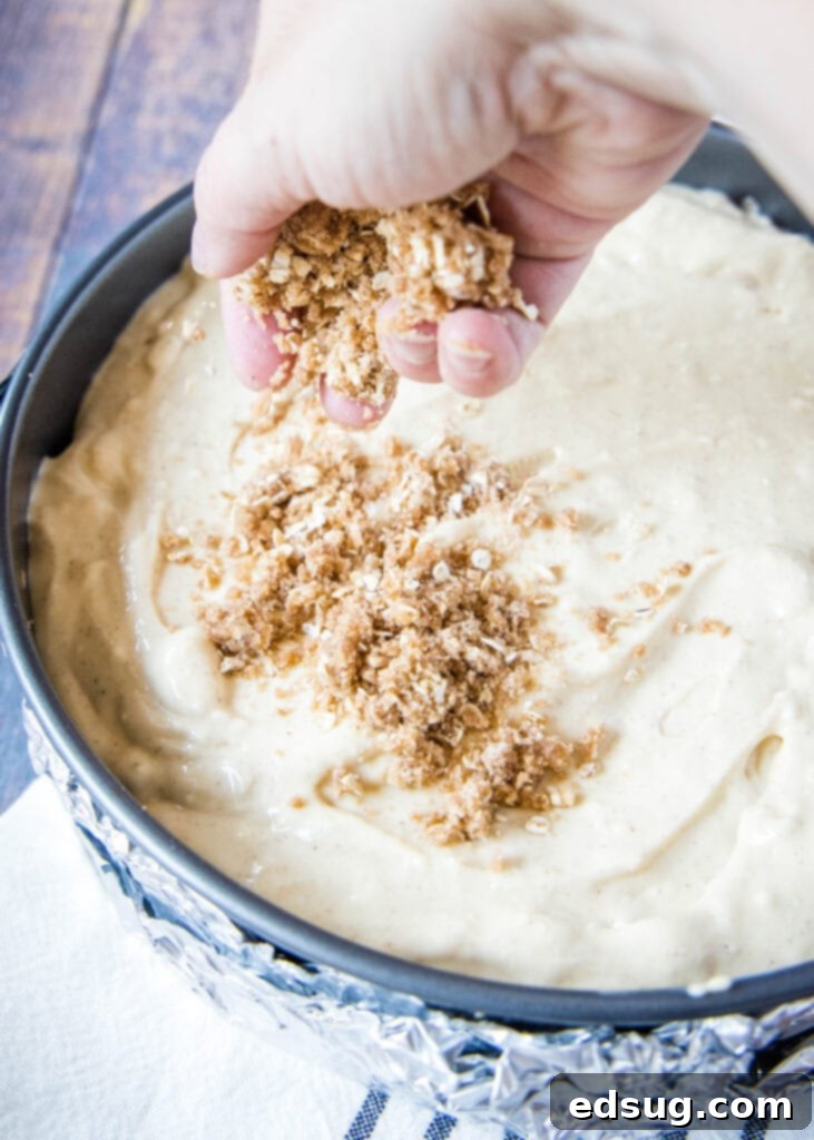 sprinkling streusel topping over cheesecake