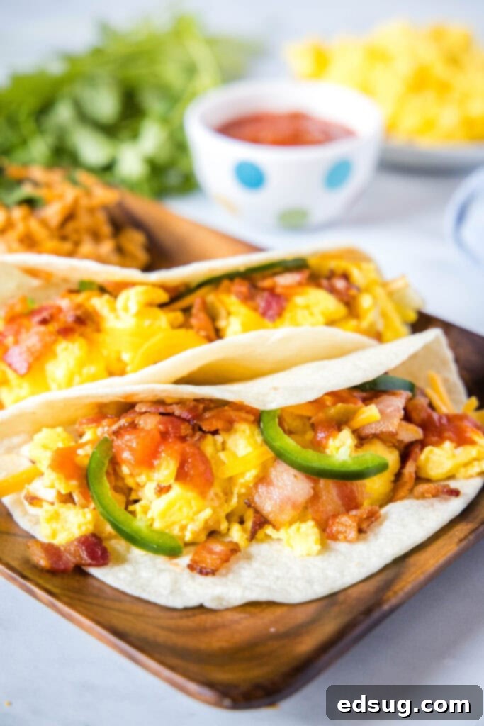 Morning Fiesta Tacos 2 breakfast tacos with bacon on a wood plate