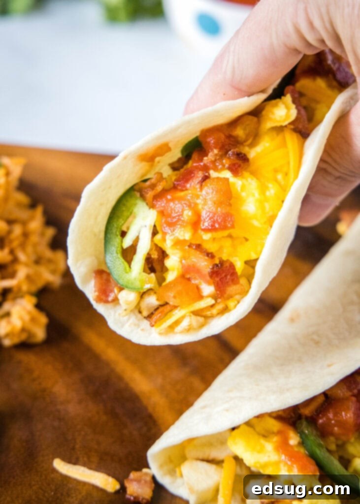 Morning Fiesta Tacos 4 holding a breakfast taco like you are ready to take a bite
