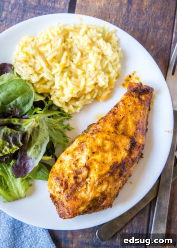 Overhead view of a plated air fryer chicken breast dinner with crisp salad and fluffy rice