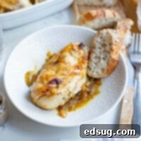 baked french onion chicken in a bowl with a slice of bread