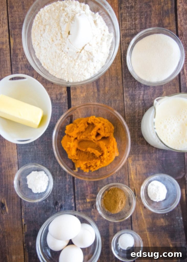 Spiced Pumpkin Waffles 3 Arrangement of fresh ingredients including all-purpose flour, granulated sugar, baking powder, baking soda, pumpkin pie spice, salt, buttermilk, eggs, pumpkin puree, and melted butter, ready for making pumpkin waffles.