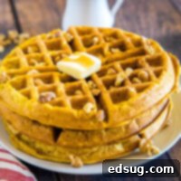 Spiced Pumpkin Waffles 7 A close-up shot of a stack of golden pumpkin waffles with a melting pat of butter on top.