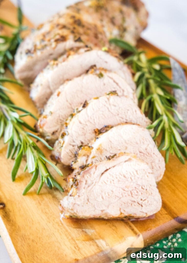 Sliced, succulent air fryer pork tenderloin on a wooden cutting board, showcasing its juicy interior