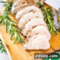 Close-up of perfectly sliced air fryer pork tenderloin on a wooden cutting board