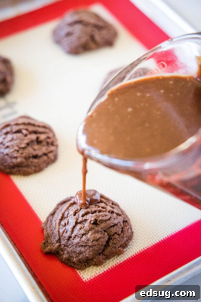 Mini Texas Sheet Cakes 3 Pouring rich, glossy chocolate frosting over a tray of freshly baked Texas Sheet Cake Cookies.