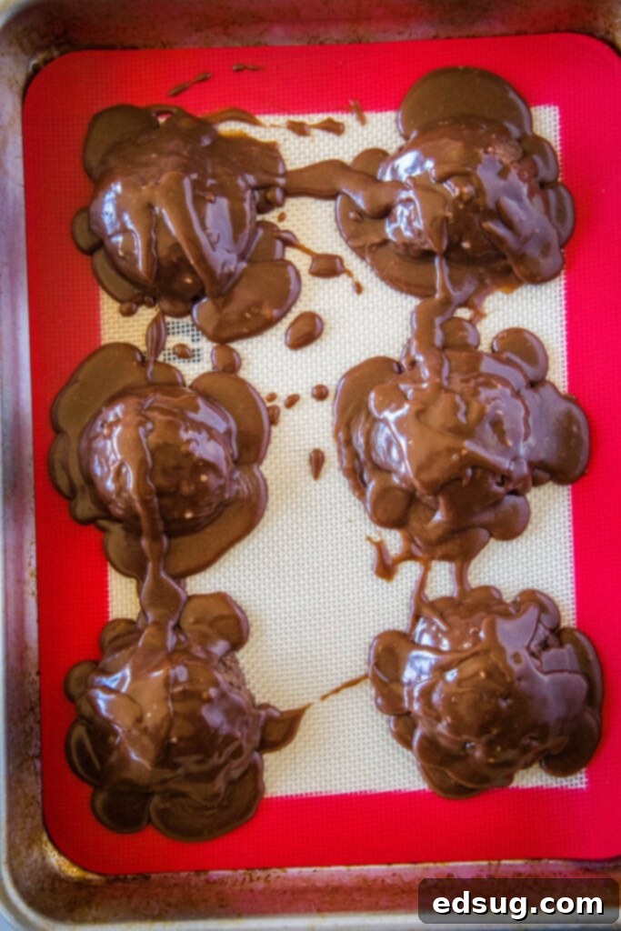 Mini Texas Sheet Cakes 4 Overhead view of a baking tray filled with Texas Sheet Cake Cookies, generously covered with smooth chocolate frosting.