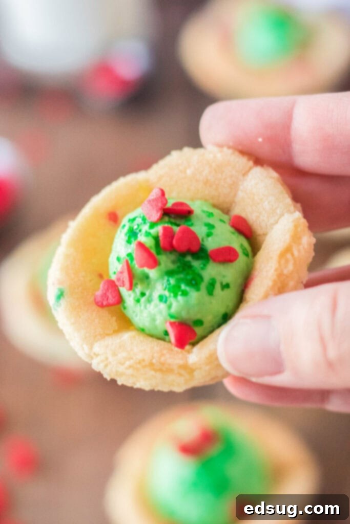 Grinchmas Sugar Cookie Bites 4 hand holding grinch sugar cookie cups