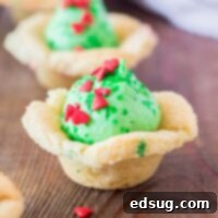 Grinchmas Sugar Cookie Bites 7 cropped in close up of a grinch sugar cookie cup topped with heart sprinkles