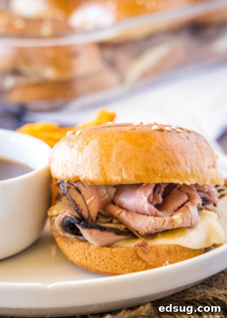 Roast beef slider on a white plate, ready for dipping.