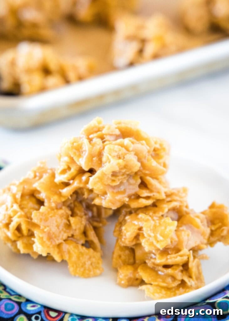 Stacked peanut butter cornflake cookies on a white plate, showcasing their crispy, chewy texture.