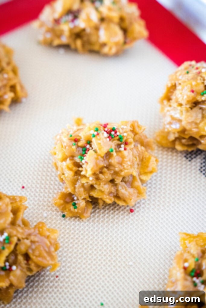 Freshly scooped no-bake cornflake cookies setting on a parchment-lined baking tray.