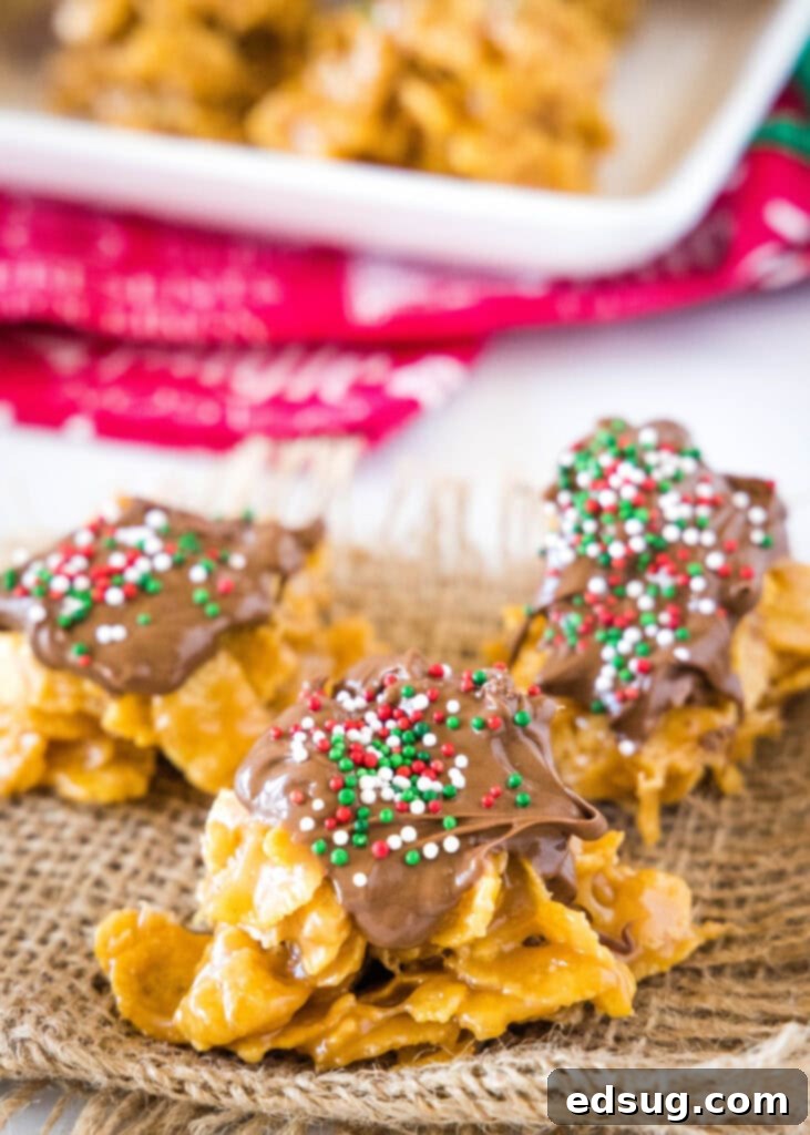 No-bake peanut butter cornflake cookies topped with melted chocolate drizzle and colorful sprinkles.
