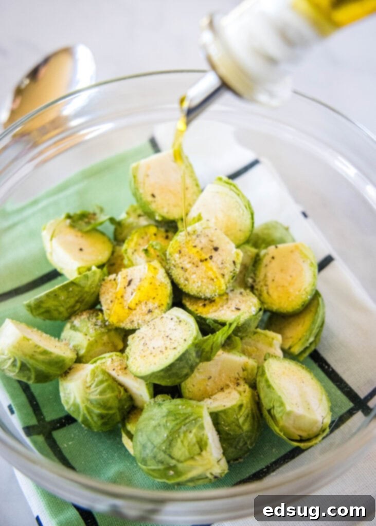 Golden Crispy Air Fryer Brussels Sprouts 3 Drizzling olive oil over fresh Brussels sprouts in a mixing bowl, preparing for air frying