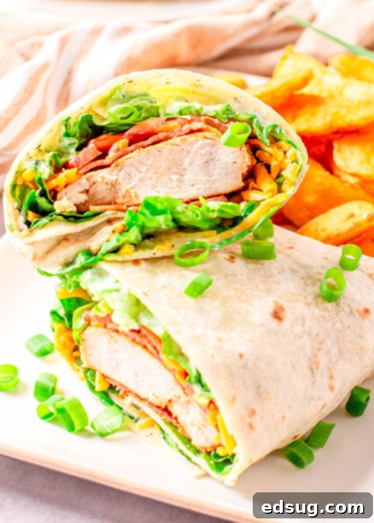 Signature Chicken Bacon Ranch Wrap 2 Two halves of a chicken bacon ranch wrap stacked on a plate, showcasing the fillings.