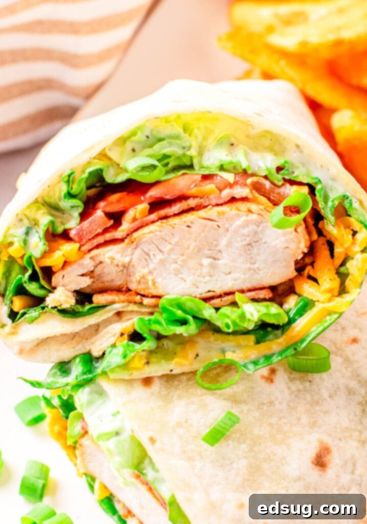 Signature Chicken Bacon Ranch Wrap 4 A chicken bacon ranch wrap cut in half, showing the cross-section of fillings.