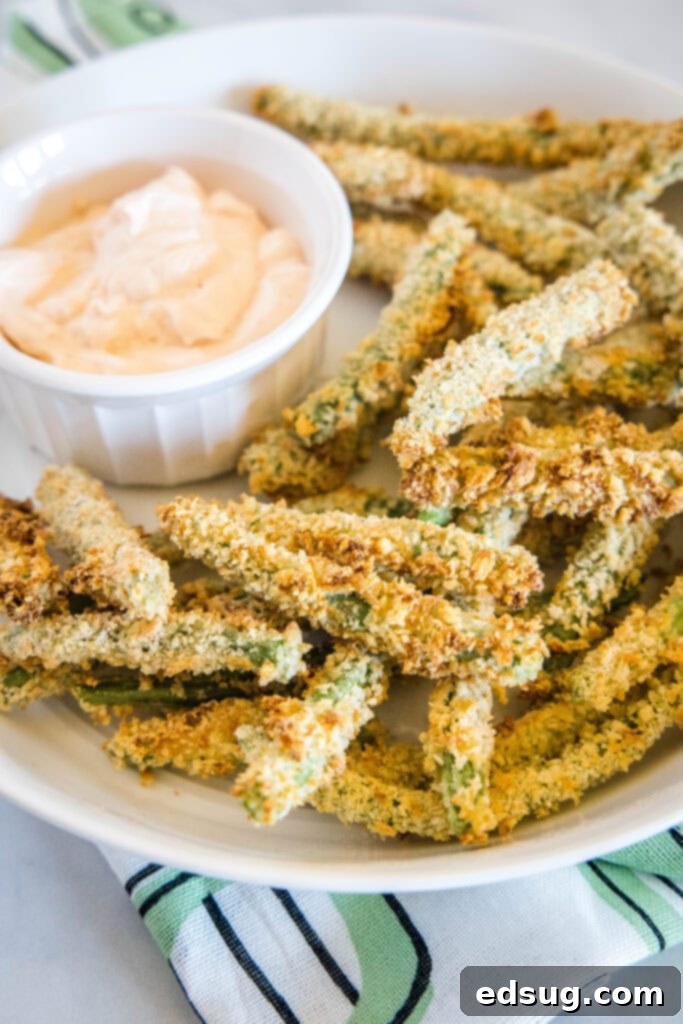 Crispy Air Fryer Green Bean Fries on a white plate with dipping sauce