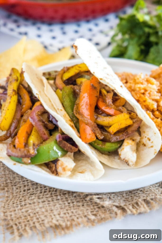 tacos loaded with fajita veggies on a white plate