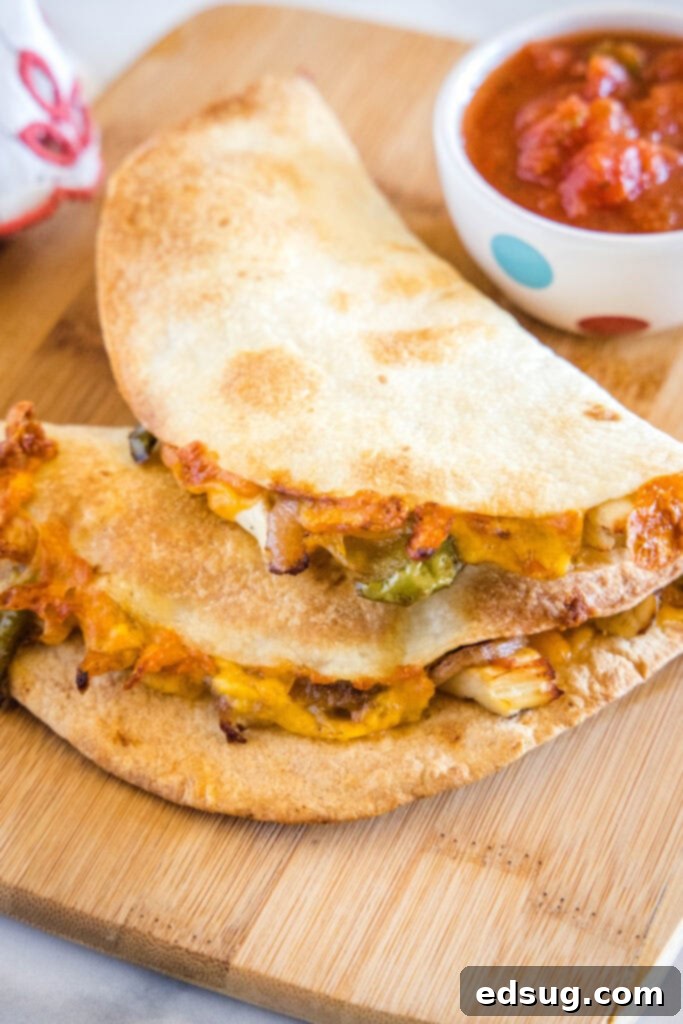 Two perfectly cooked, golden-brown quesadillas, sliced in half, resting on a rustic cutting board, showcasing their melted cheese and filling. Ideal for a quick air fryer meal.