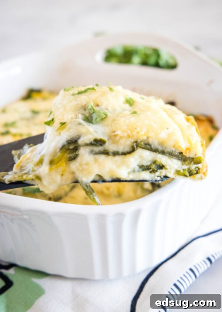 taking a slice of chili relleno casserole out of baking dish