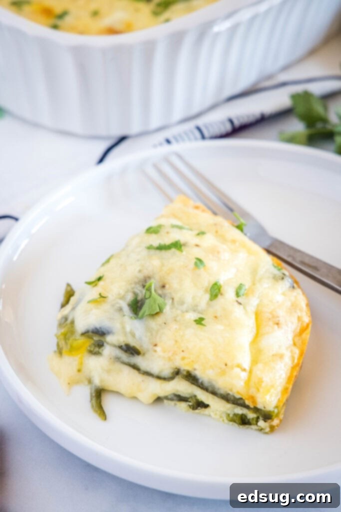 looking down on a white plate with a slice of chili relleno casserole and fork