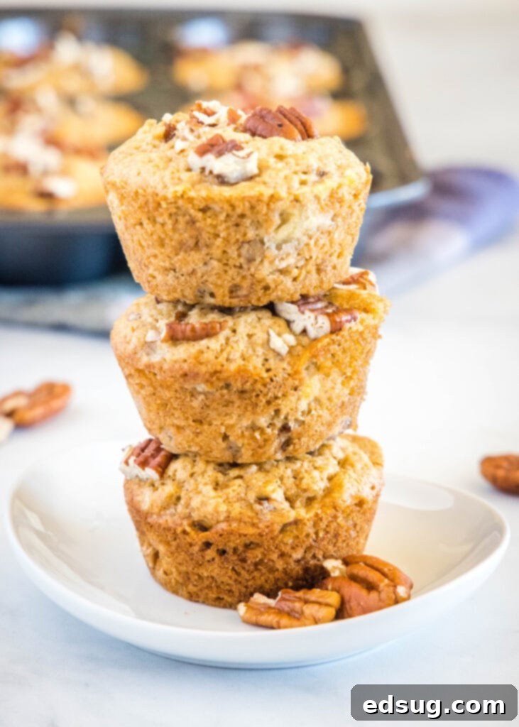 Perfect Banana Nut Muffins 2 stacked banana muffins with nuts on a white plate