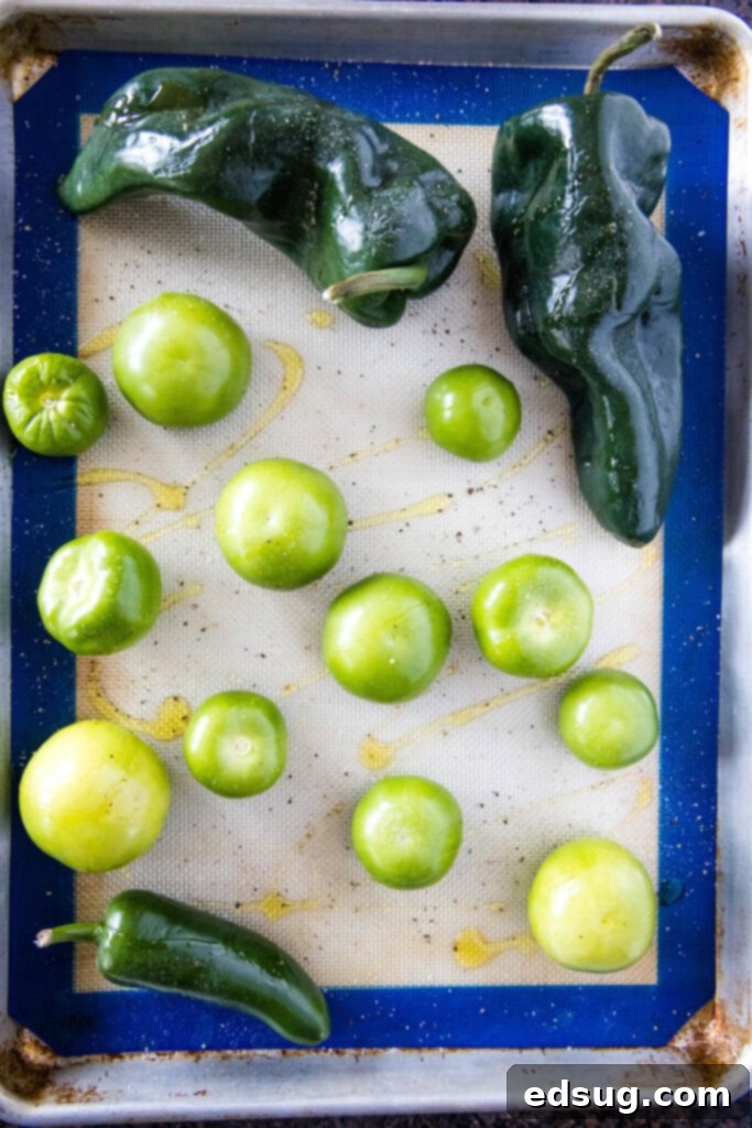 Effortless Instant Pot Pozole 3 salsa verde ingredients on a baking tray, ready for roasting for homemade pozole
