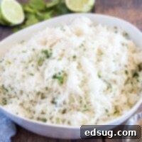 Close up view of cilantro lime rice in a white bowl, showing its texture and fresh ingredients.