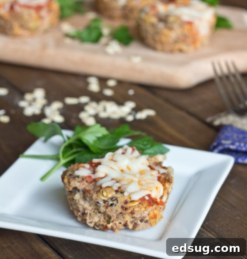 Individual Turkey Quinoa Muffin Cup Serving A single turkey quinoa muffin cup on a white plate, ready to be eaten, with a fork next to it.
