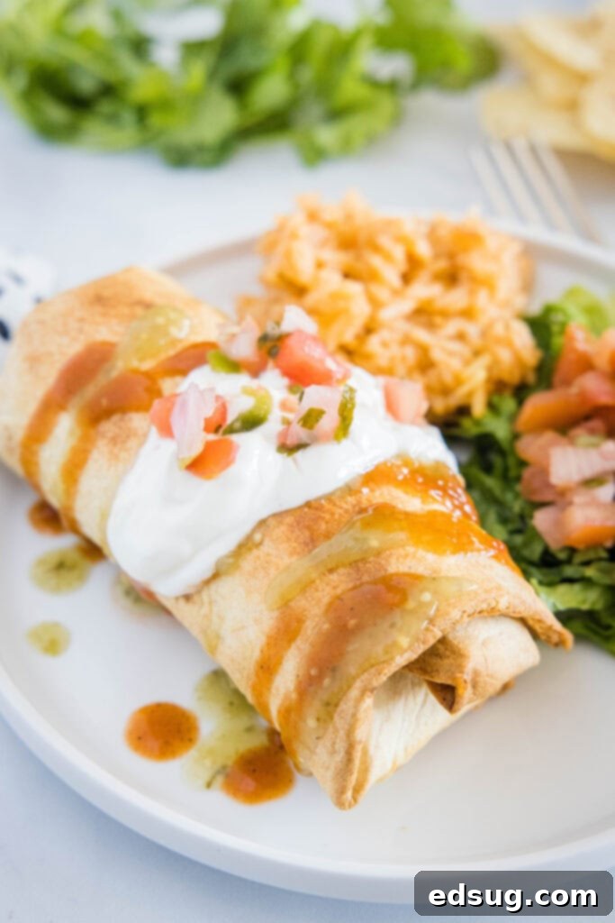 air fryer chimichanga on a plate topped with sour cream