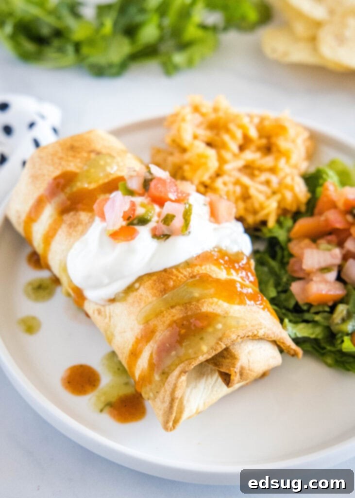 chimichanga on a plate with sour cream on top