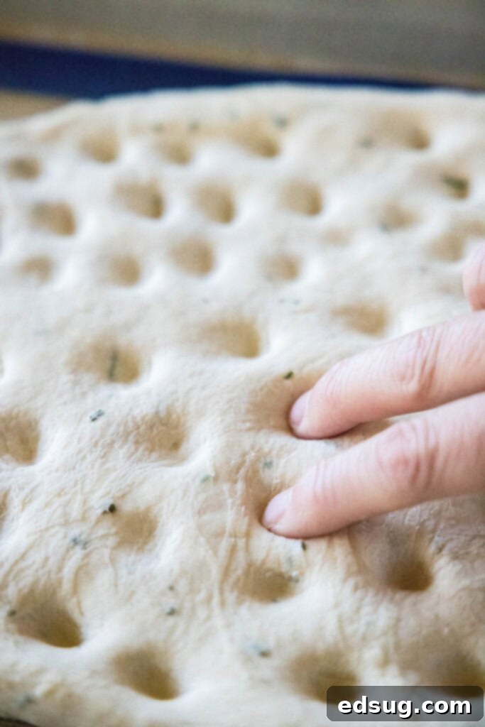 Aromatic Rosemary Focaccia 4 pressing dimples into focaccia bread