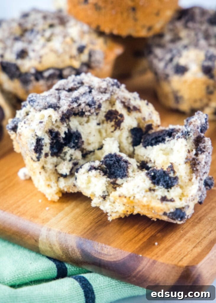 Oreo muffin broken open to show inside with chunks of cookies