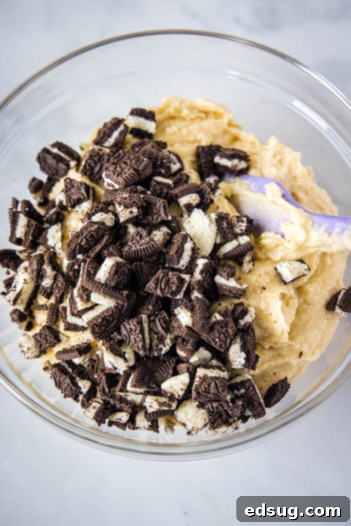 folding oreo cookies into muffin batter in a mixing bowl