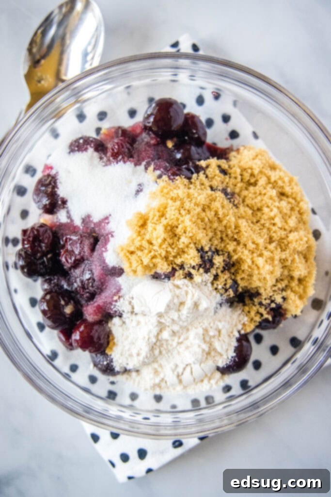 Classic Cherry Cobbler 4 Ingredients for cherry cobbler including fresh cherries, granulated sugar, brown sugar, and flour, arranged in bowls.