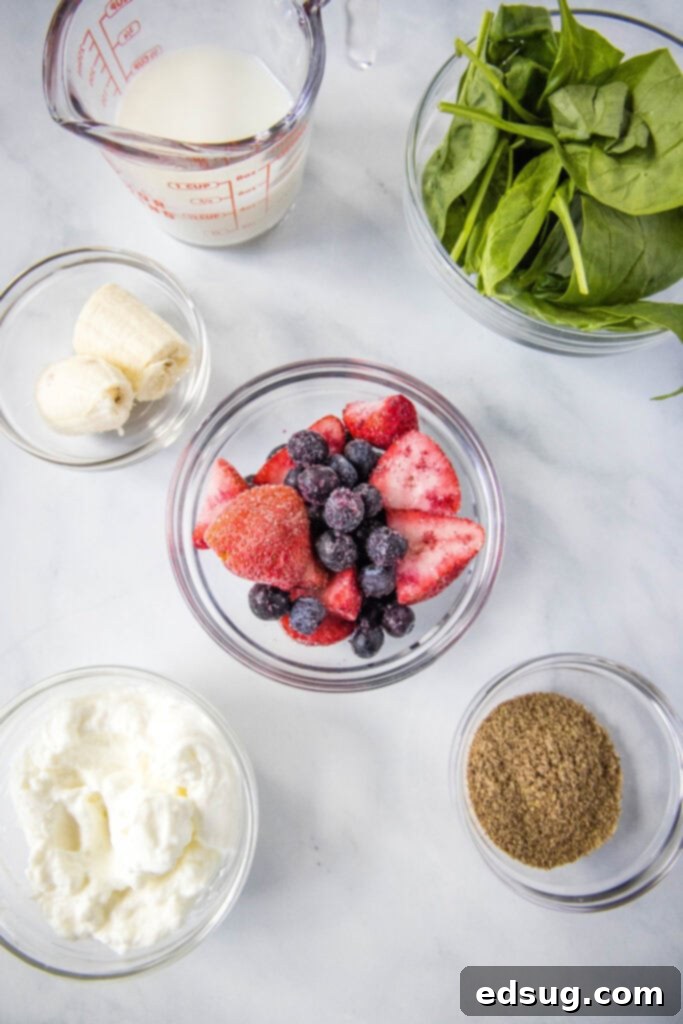 Berry Burst Smoothie 3 Various healthy ingredients for a mixed berry smoothie, including fresh berries, banana, spinach, and yogurt