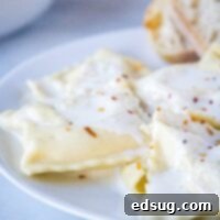 close up homemade ravioli on a plate with white sauce