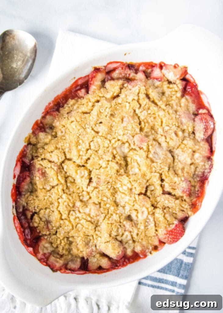 Irresistible Strawberry Crumble 2 Freshly baked strawberry crumble with a golden brown topping, served warm on a kitchen towel, ready to be enjoyed.