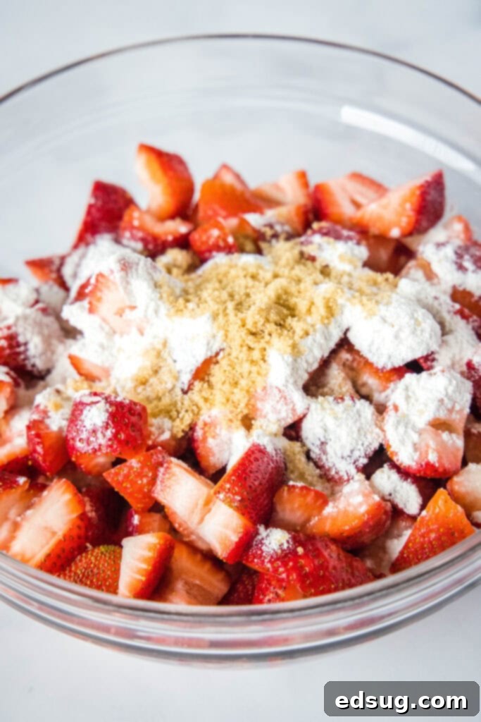 Irresistible Strawberry Crumble 3 Bowl of fresh strawberries mixed with flour and brown sugar, ready for the crumble topping application.