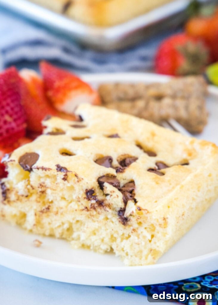 Sliced sheet pan pancake on a white plate with syrup