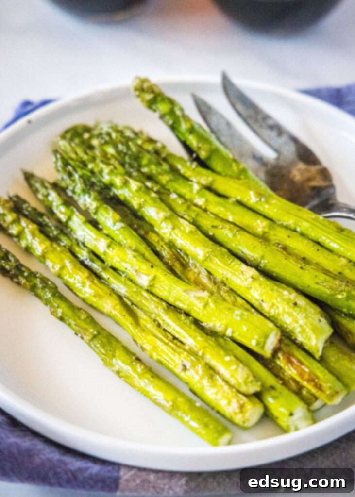 Another view of roasted asparagus served on a white plate, highlighting its appetizing texture and appealing presentation.