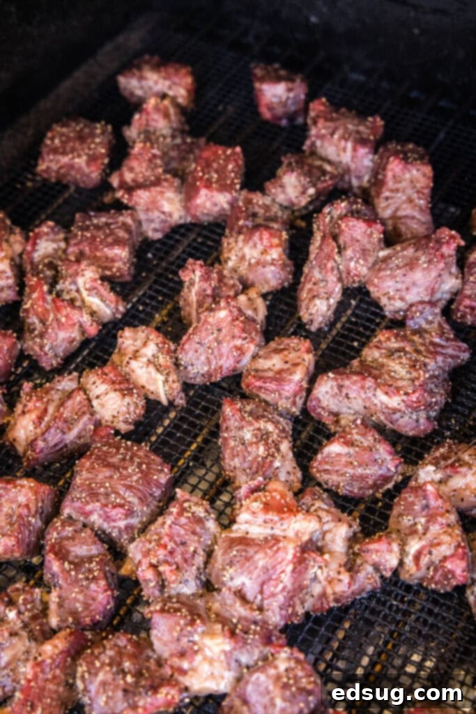 Burnt Ends on a Budget 3 Poor man's burnt ends smoking on a grill, showing the early stages of bark formation
