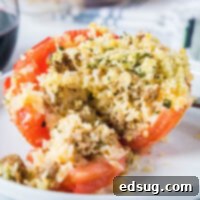 close up baked stuffed tomato cut open to see rice and sausage