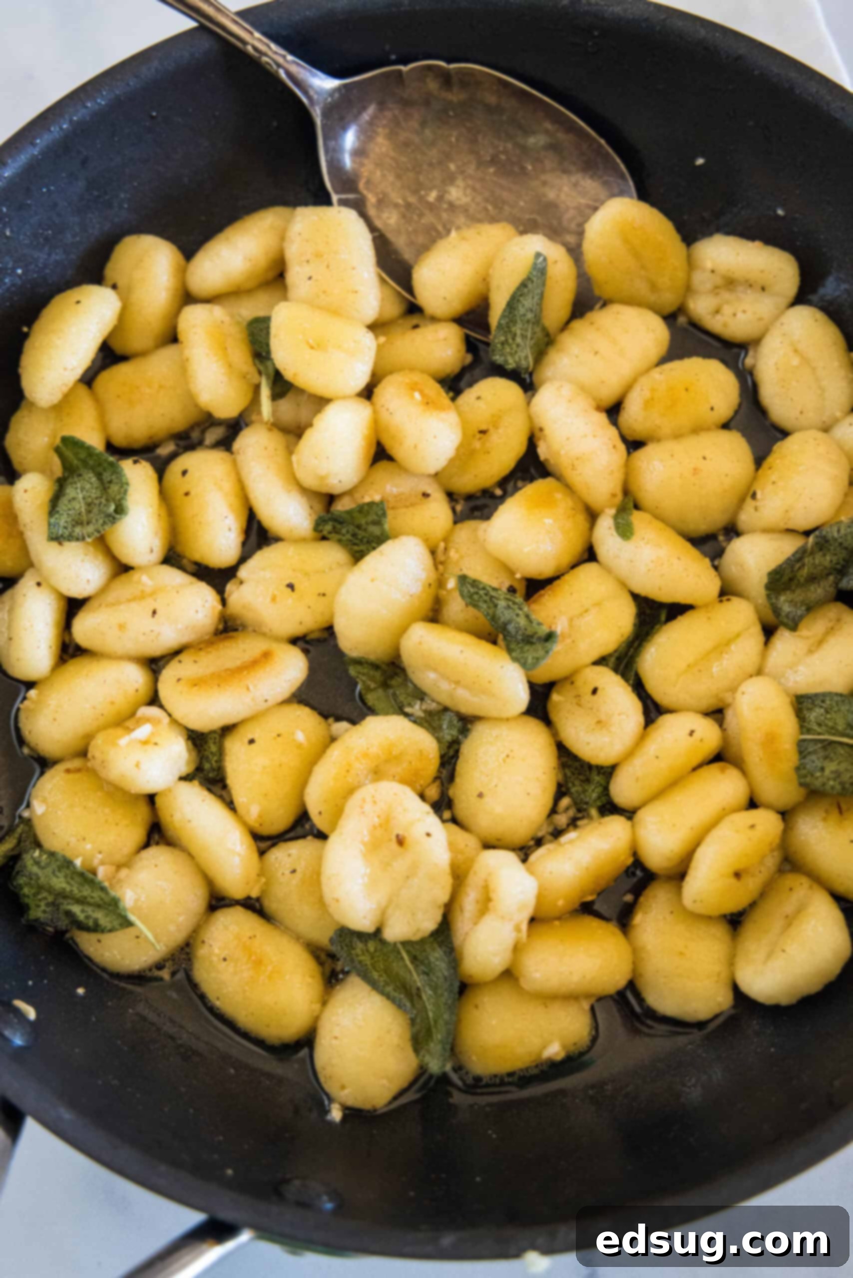 Make this quick weeknight brown butter gnocchi tossed in a rich, nutty browned butter sauce with sage. It's ready in 20 minutes! Close-up overhead view of golden-brown gnocchi tossed in a rich brown butter sauce with vibrant green sage leaves in a skillet.